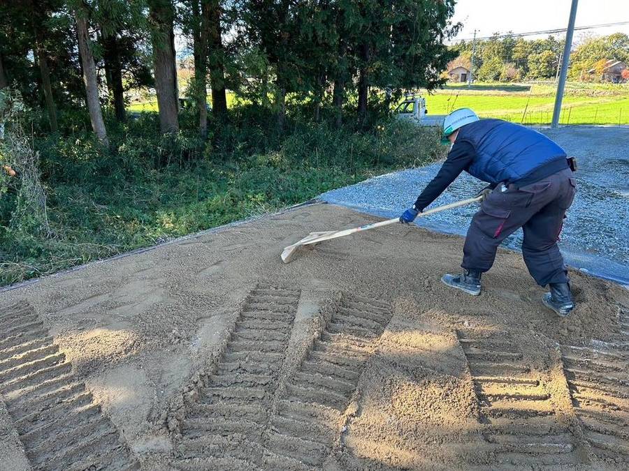 現場で砂をならす作業員